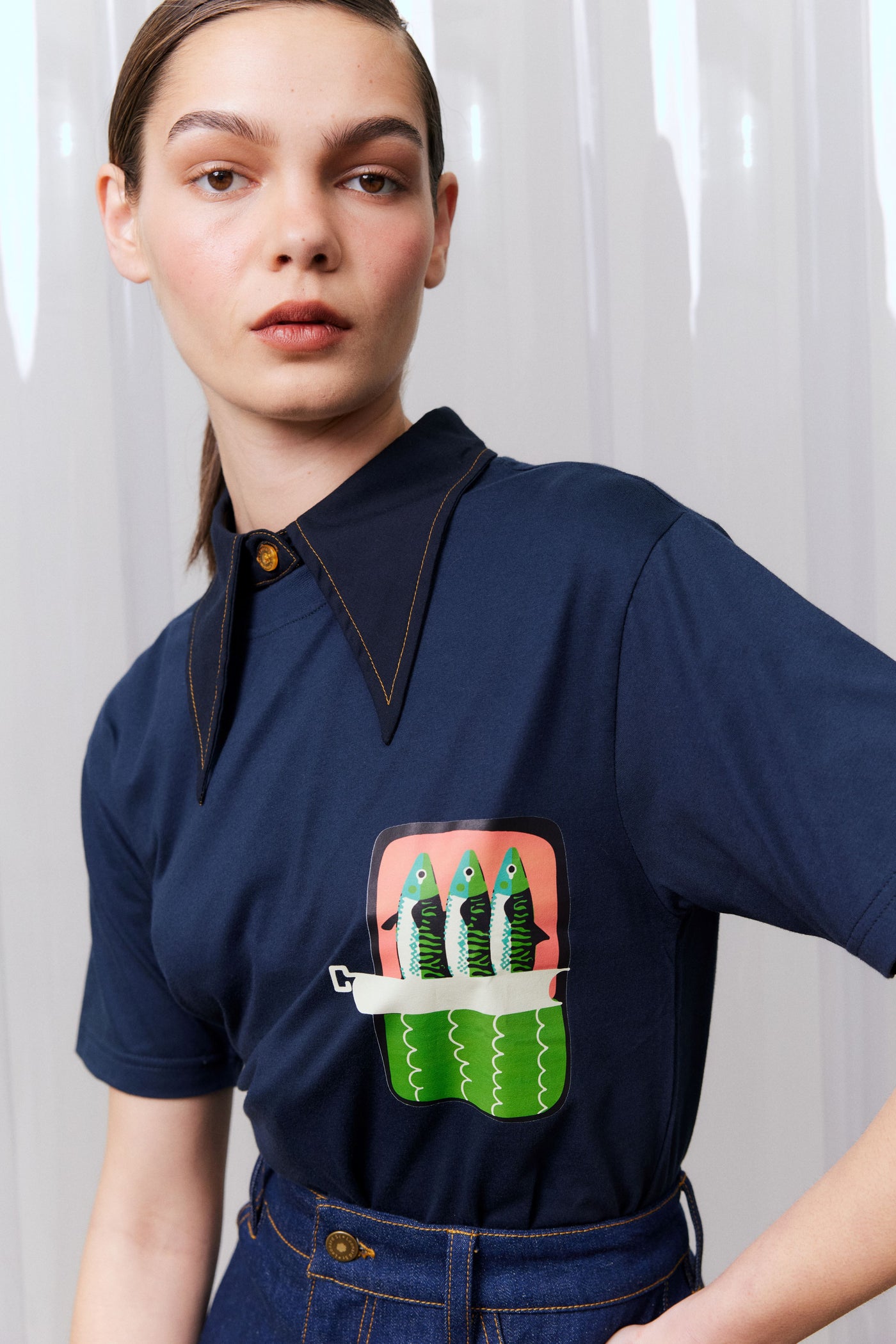 Person wearing a navy blue shirt with a unique design on a white background