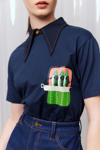 Navy blue t shirt with a graphic of three fish in a pocket on a plain background