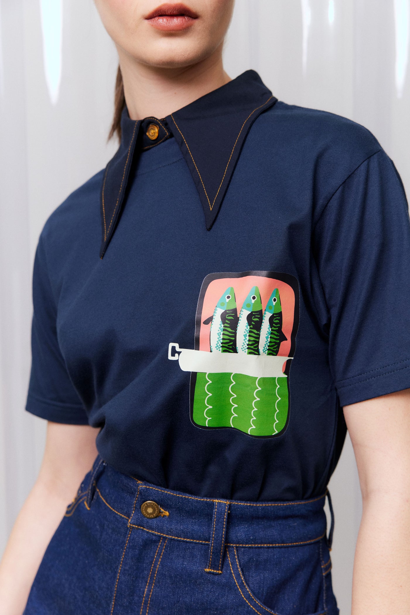 Navy blue shirt with a colorful pocket design featuring fish on a plain background