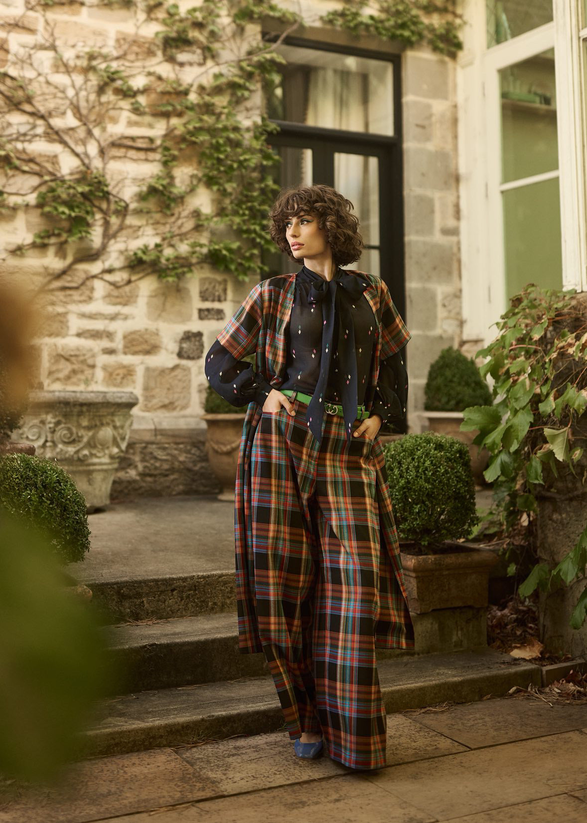Woman in plaid outfit standing in a garden setting