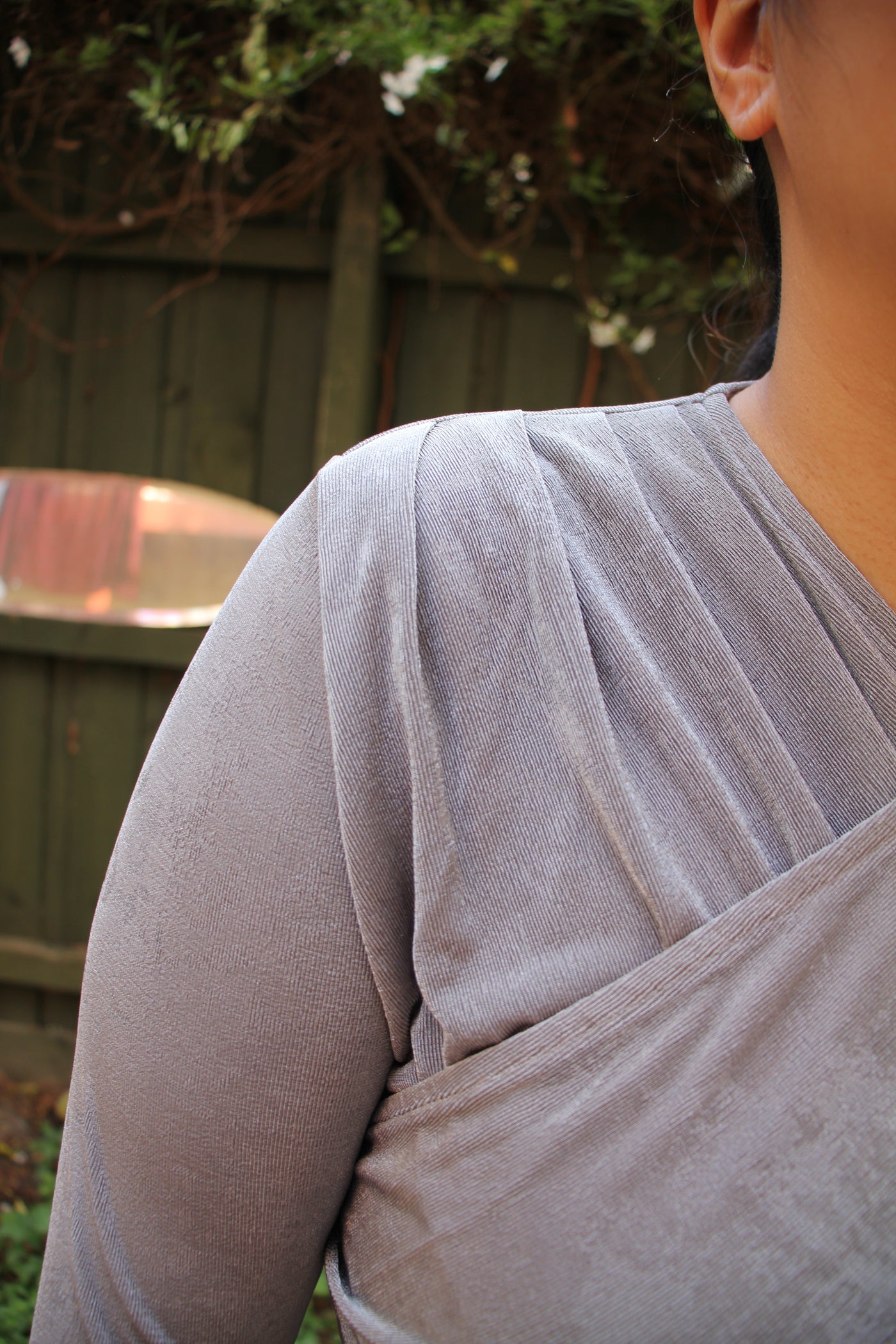 Close-up of a person wearing a light gray shirt with a blurred background