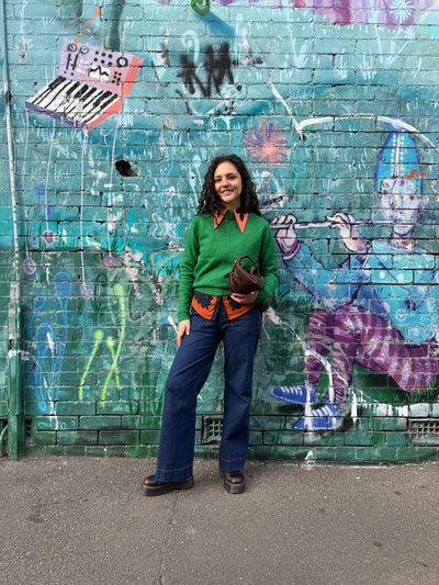 Person standing in front of a colorful graffiti-covered wall