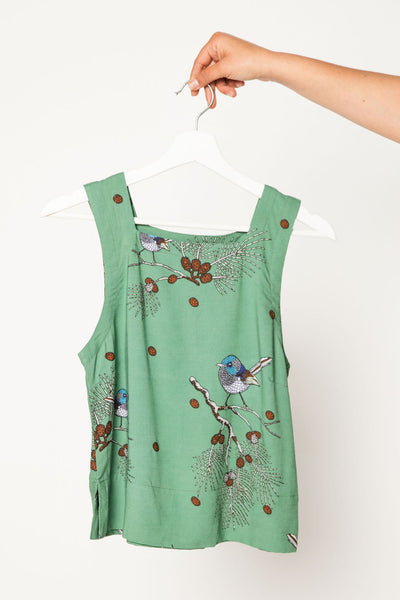 Green sleeveless top with bird and branch pattern on a white background