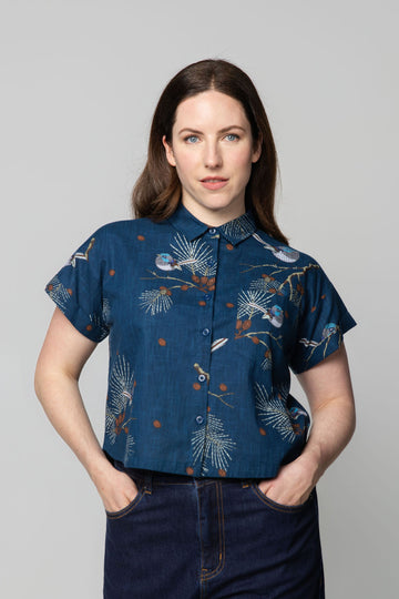 Woman wearing a blue fairy wren patterned shirt against a gray background
