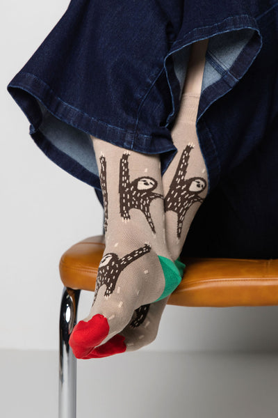 beige socks with animal design worn by a person sitting on a chair.