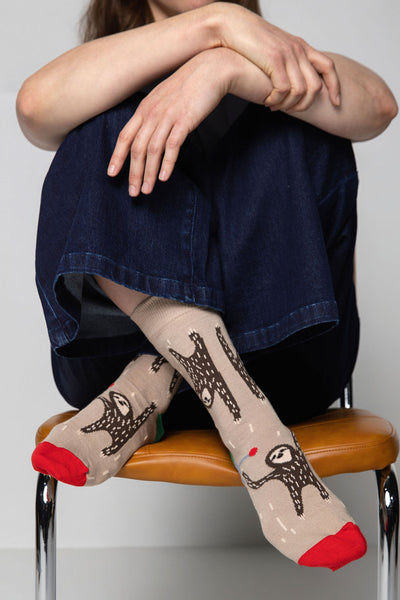 Person wearing socks with animal designs sitting on a chair.