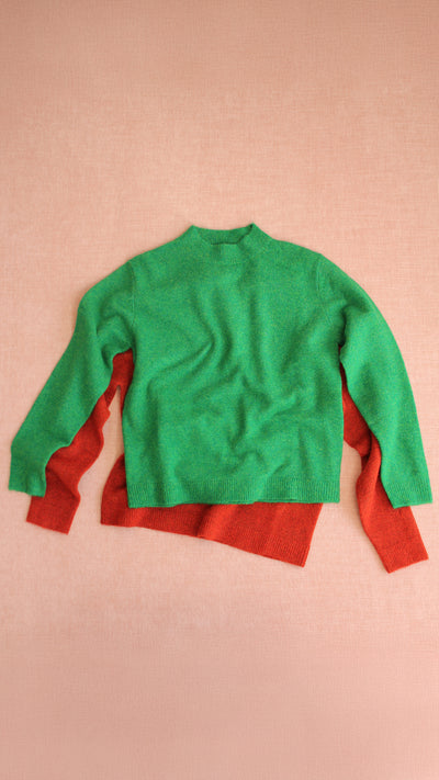 Green and red sweater on a pink background