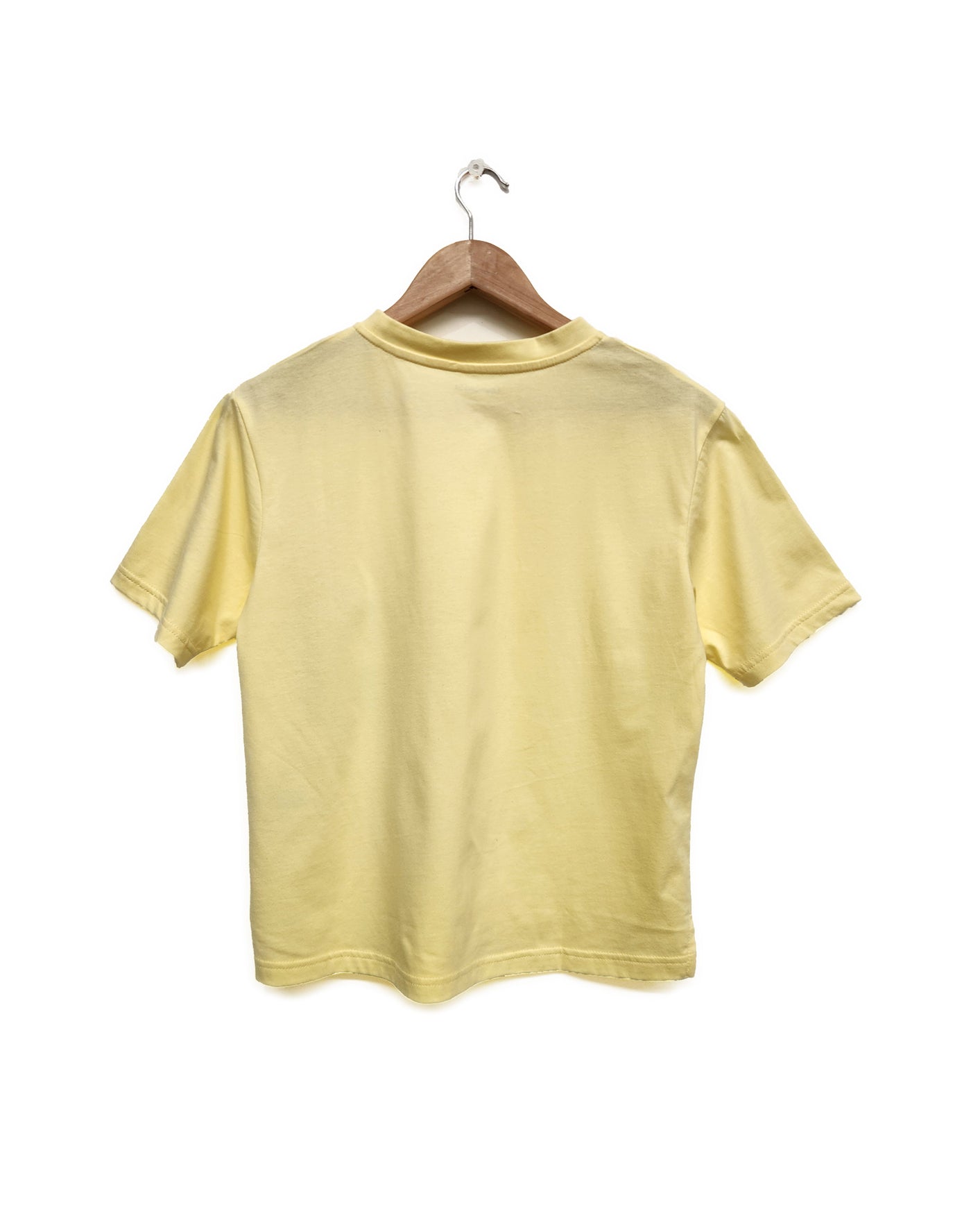 Yellow t-shirt on a wooden hanger against a white background